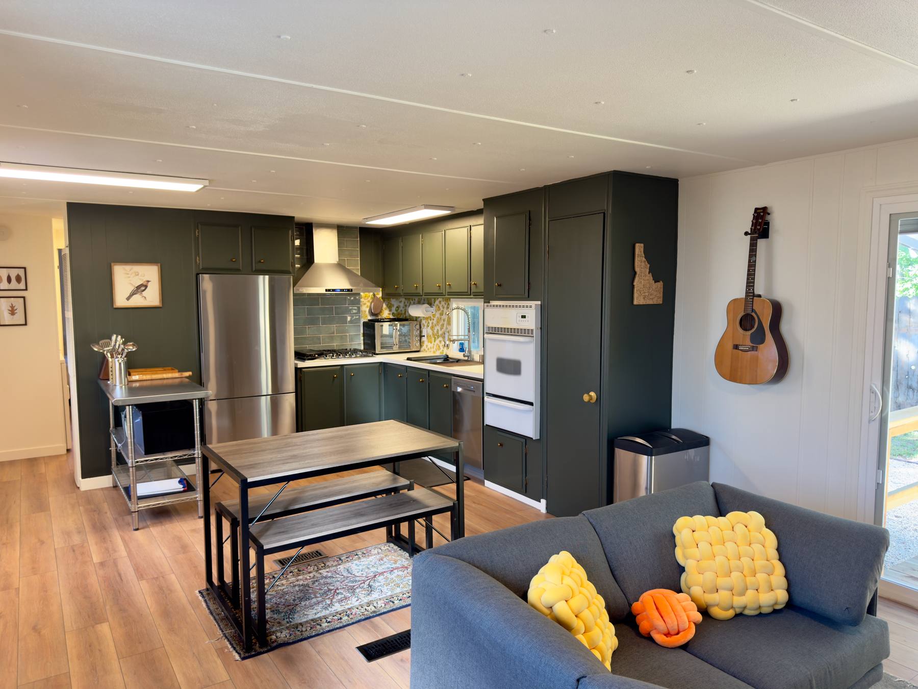 Living area looking through to the kitchen island and deep green cabinetry